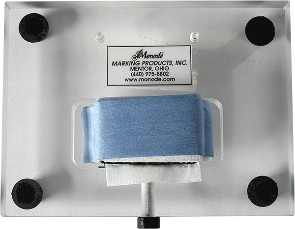 Bottom view of an electrochemical marking fixture with a Monode Marking Products label and a blue felt pad