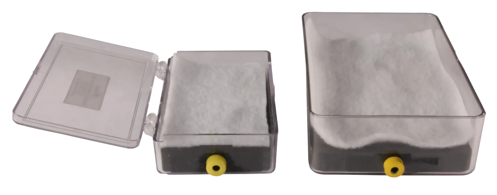 Two clear plastic boxes with white padding and yellow ports, one open and one closed